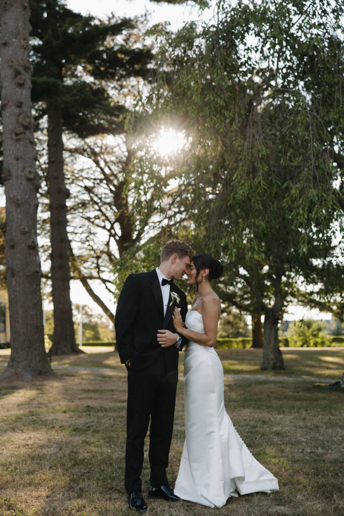 Bride and groom leaning in, a quiet moment before the outdoor wedding reception. 