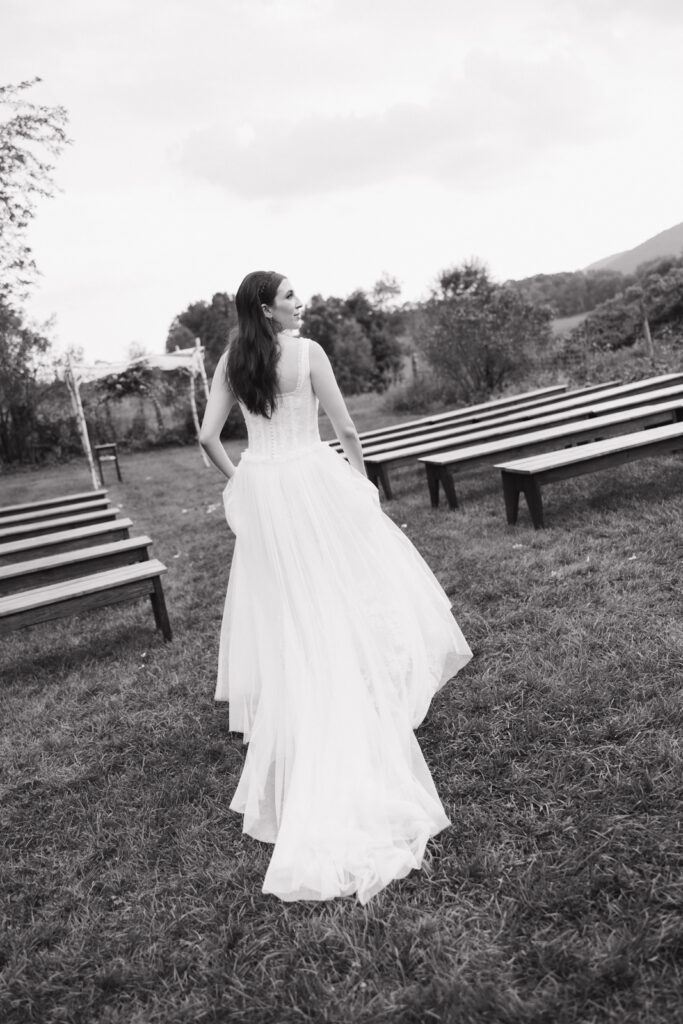 Intimate wedding photographer of the bride walking down the aisle of an intimate outdoor wedding in upstate New York. Black and white documentary-style wedding photography.