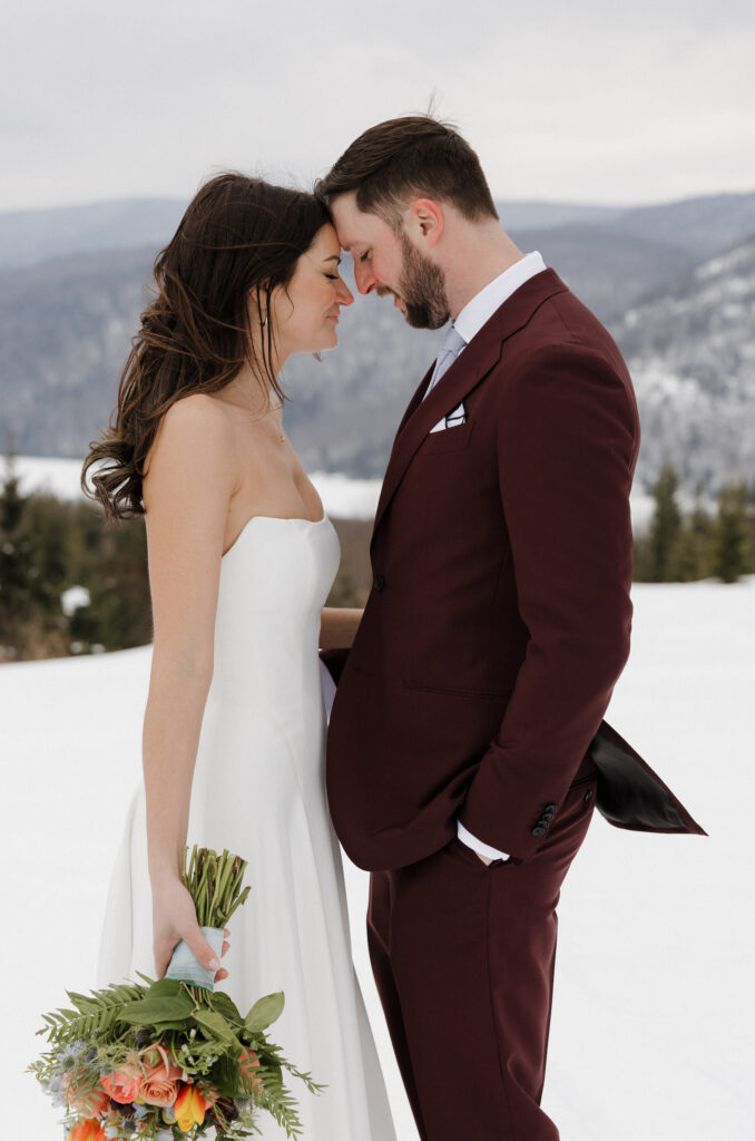 The bride and groom stand face-to-face with smiles after their outdoor ceremony.