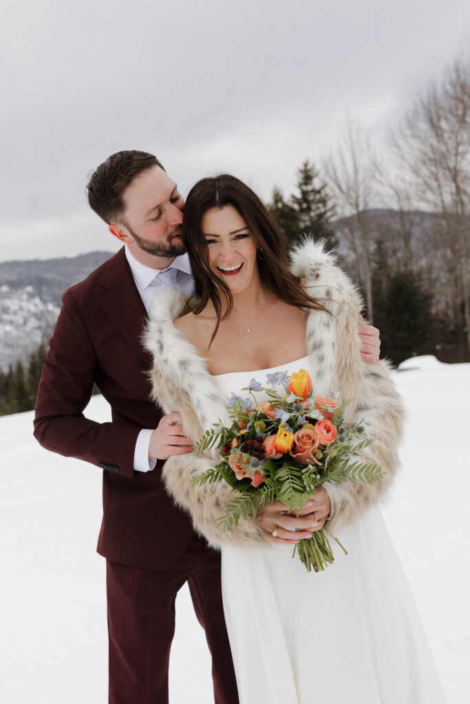 Documentary style wedding photographer captures the bride and groom laughing together in excitement after their winter wedding ceremony.