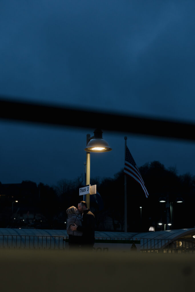 Romantic nighttime photo of a couple embracing under a streetlight during a couples photography session.