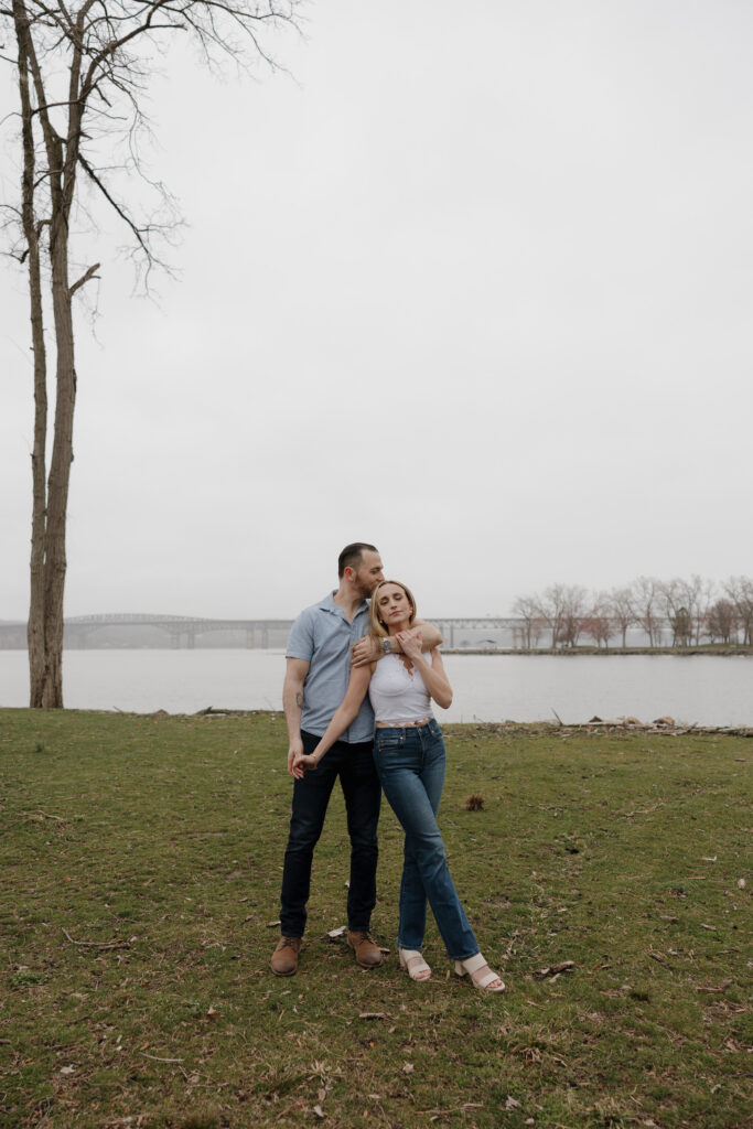 couple wrapped up together during their engagement session on the water 