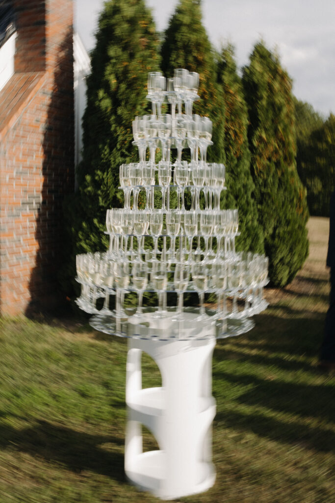 blurry photo of a champagne tower at a wedding outdoors 
