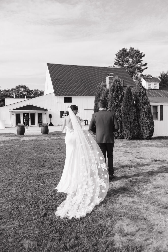 black and white documentary photo of bride and groom walking together 