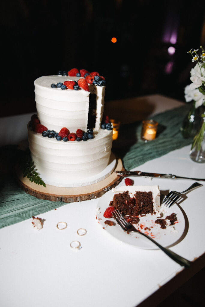 direct flash style photo of wedding cake after the first slice has been cut 