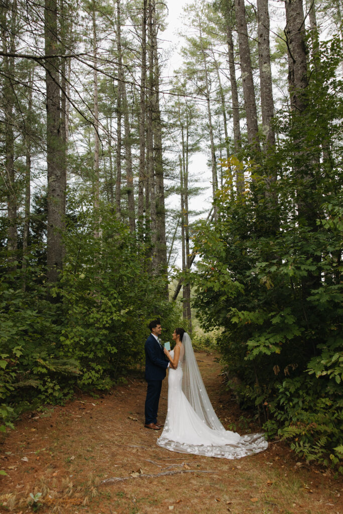 a couple after seeing each other for the first time, reading their heart felt vows in the forest 