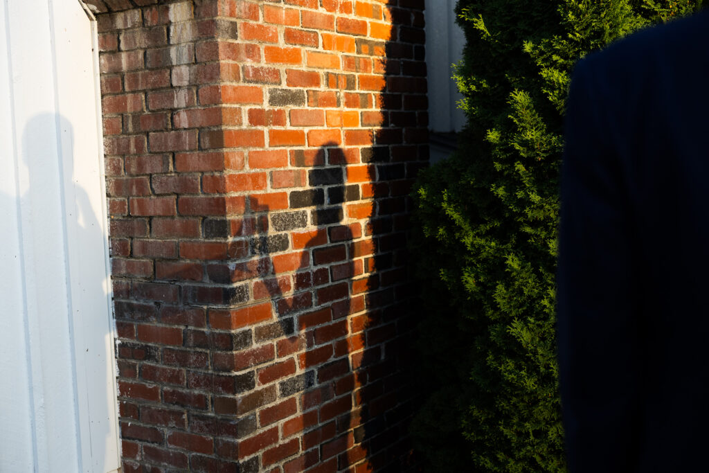 bride and groom cheers their champagne glasses, photo of their shadows on a wall 